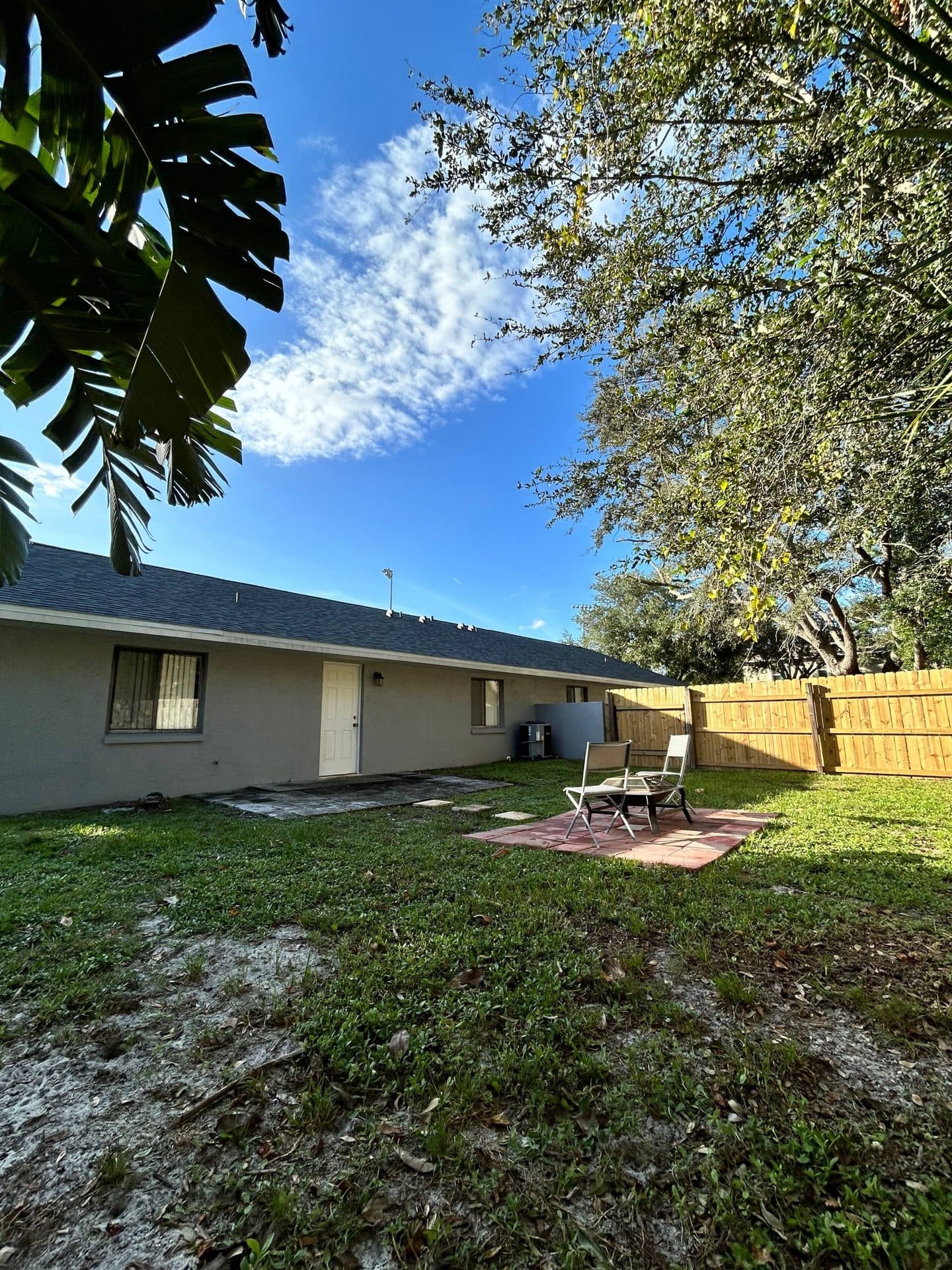 Fenced backyard with green lawn