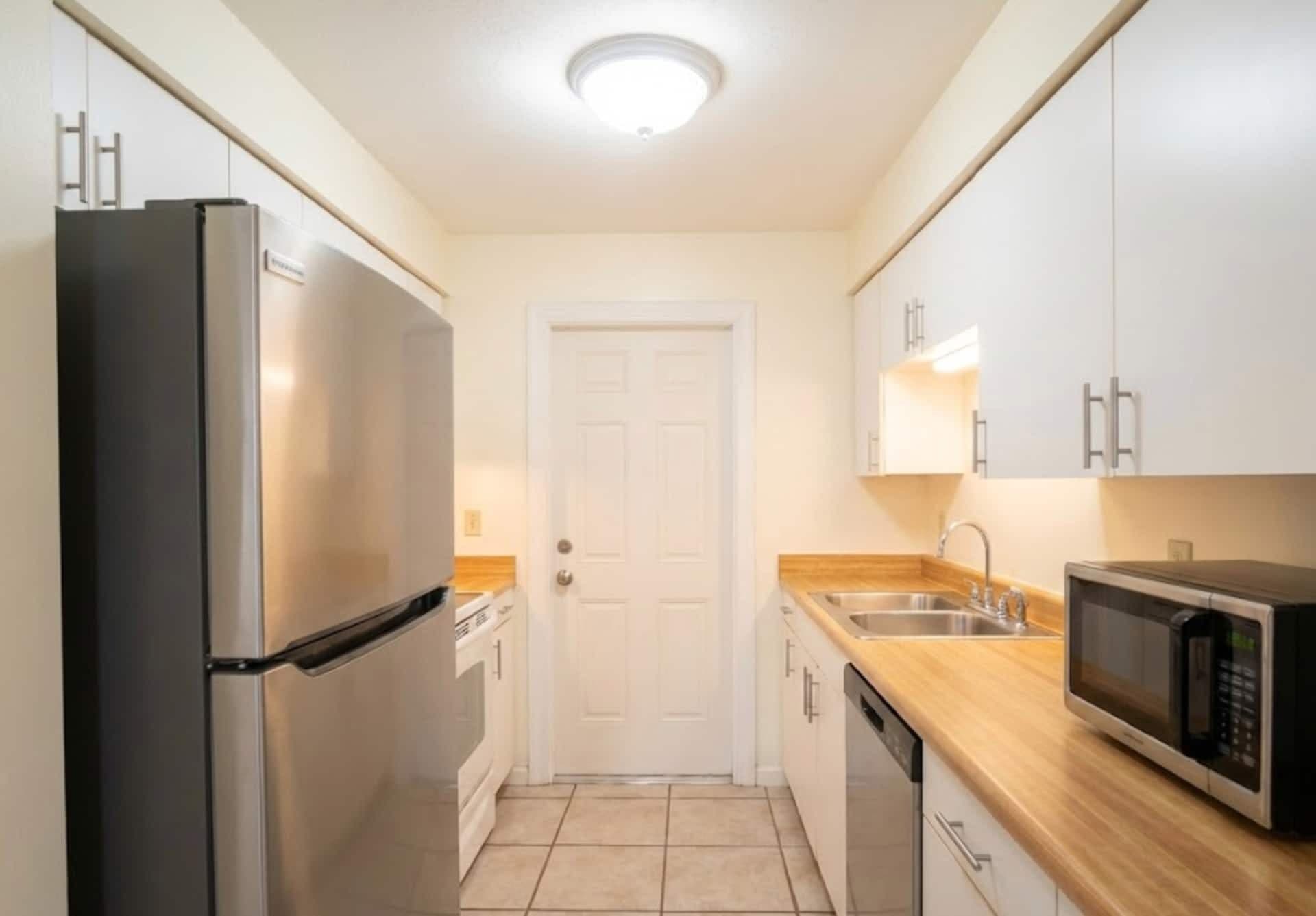 Full kitchen with stainless refrigerator and butcher-block counters